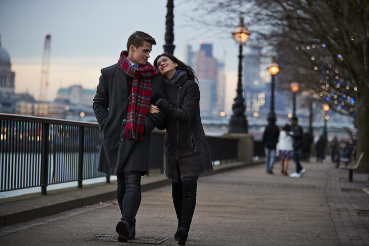 Couple Walking Along South Bank On Winter Visit To London