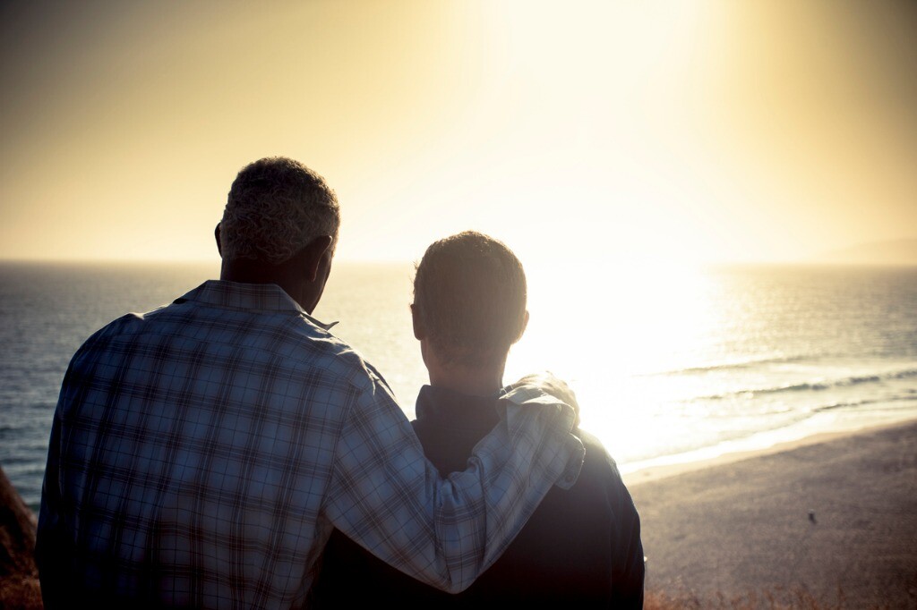 Gay couple looking at sunset