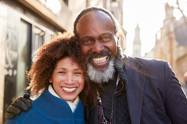 Senior Couple Walking Together Through A City In Autumn