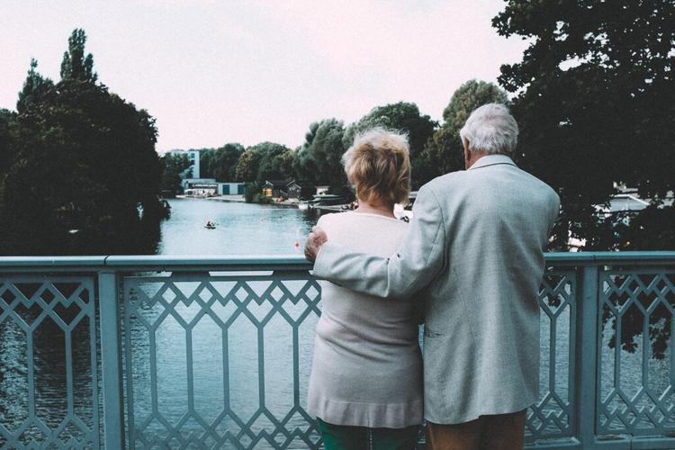 older couple standing on bridge