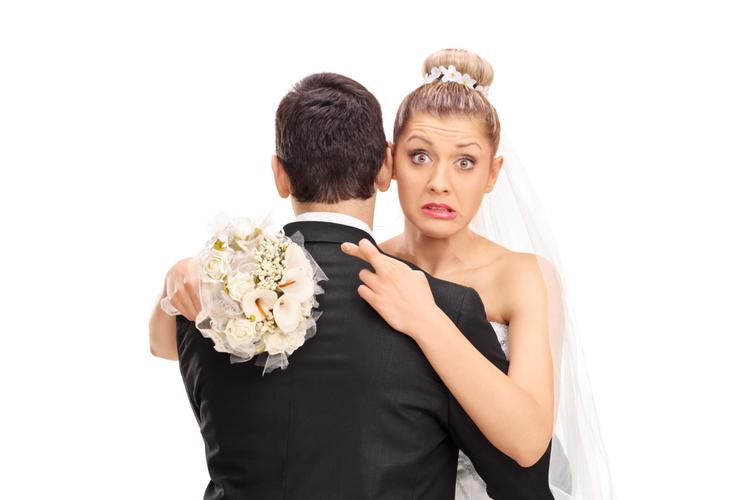 bride hugging husband with crossed fingers