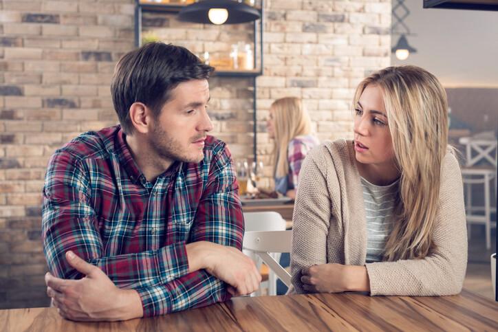 Young couple having a serious conversation in a bar.