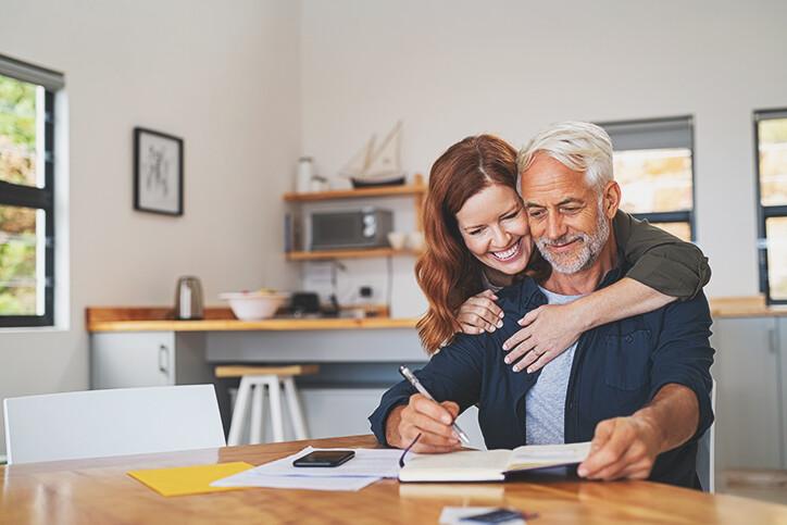 Age gap couple embracing at table