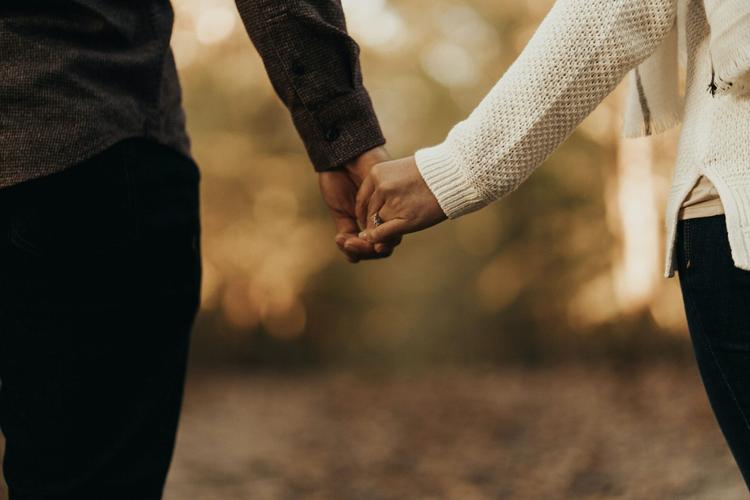 A happy couple holding hands after being matched by Maclynn's dating agency in London.