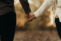 A happy couple holding hands after being matched by Maclynn's dating agency in London.