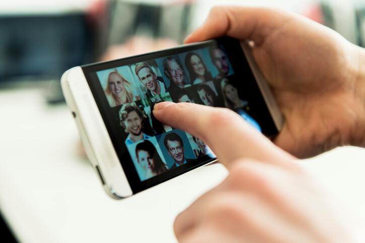 Mobile phone full of small portrait photos. Concept of social networking.