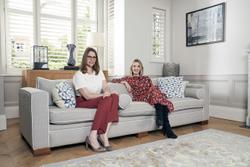 Two members of the Maclynn team, sitting on a sofa