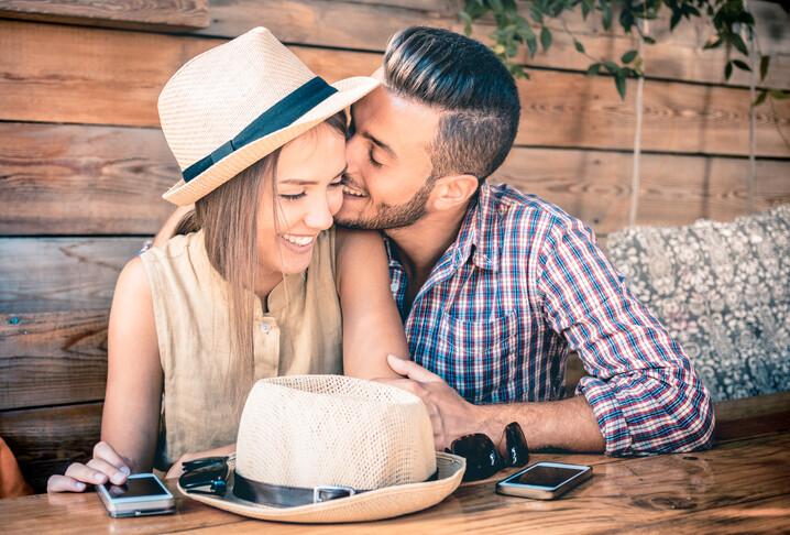 Young fashion couple of lovers at beginning of love story - Handsome man whispers sexy kisses in pretty woman ear - Relationship love concept with boyfriend and girlfriend together - Warm retro filter