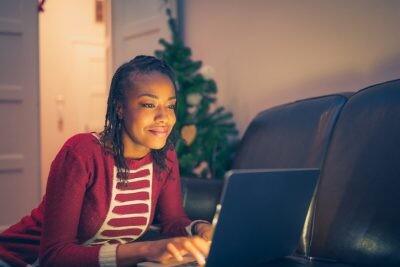 African American woman online Christmas shopping at home and virtual shopping