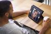 Afro american male on the digital tablet conference call. Young woman on the other side. Sitting in coffe shop with cup of coffee for their long-distance relationship