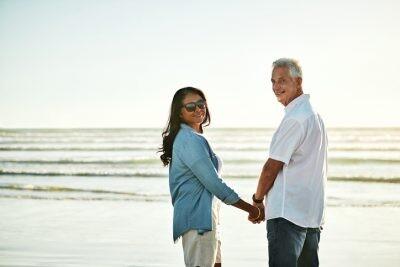 Portrait of a happy senior couple spending a day at the beach, looking back on the past
