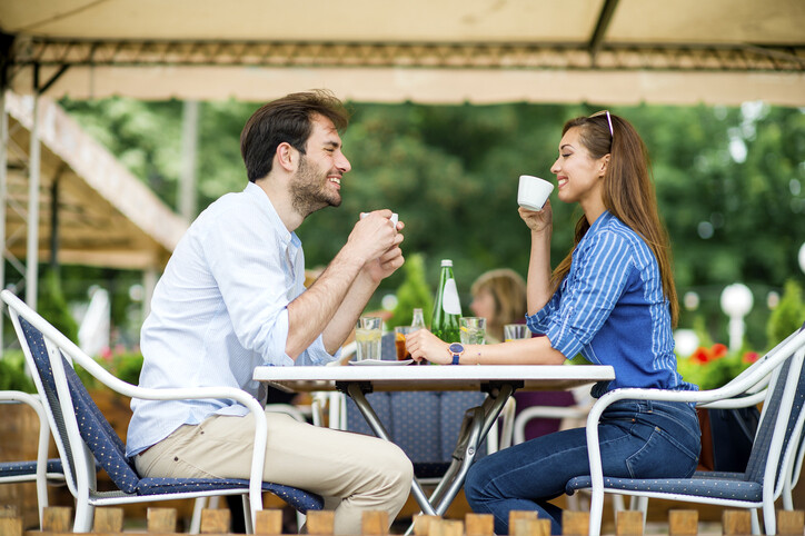 Loving couple at coffee house having coffee and chatting